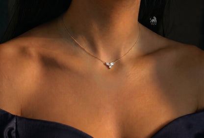The Elara Three-Stone Diamond Necklace worn around the neck